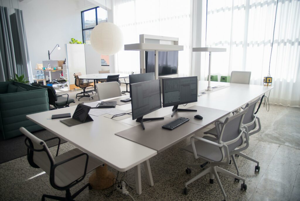 Empty office with a single computer screen illuminated, symbolising the unseen energy consumption of idle workplace technology.